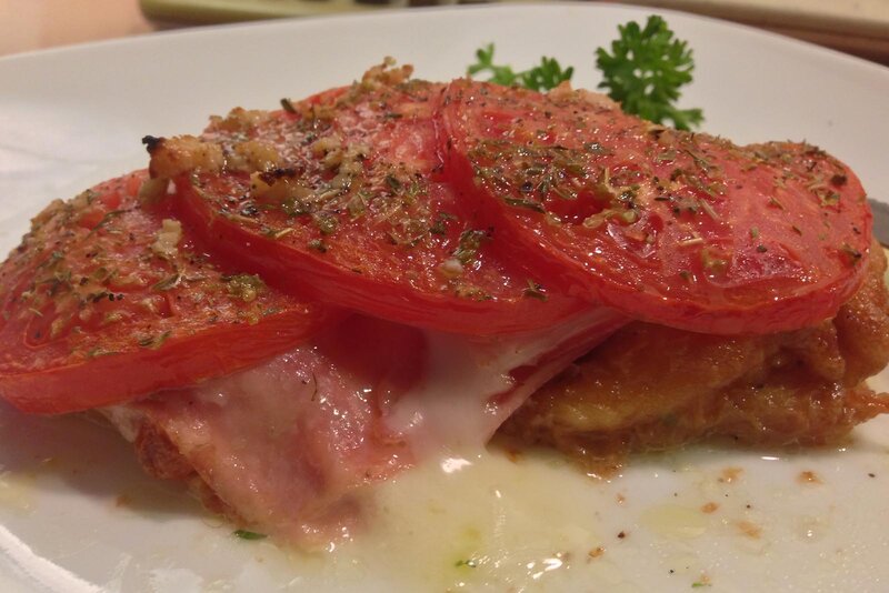 Fried fish topped with sliced tomatoes